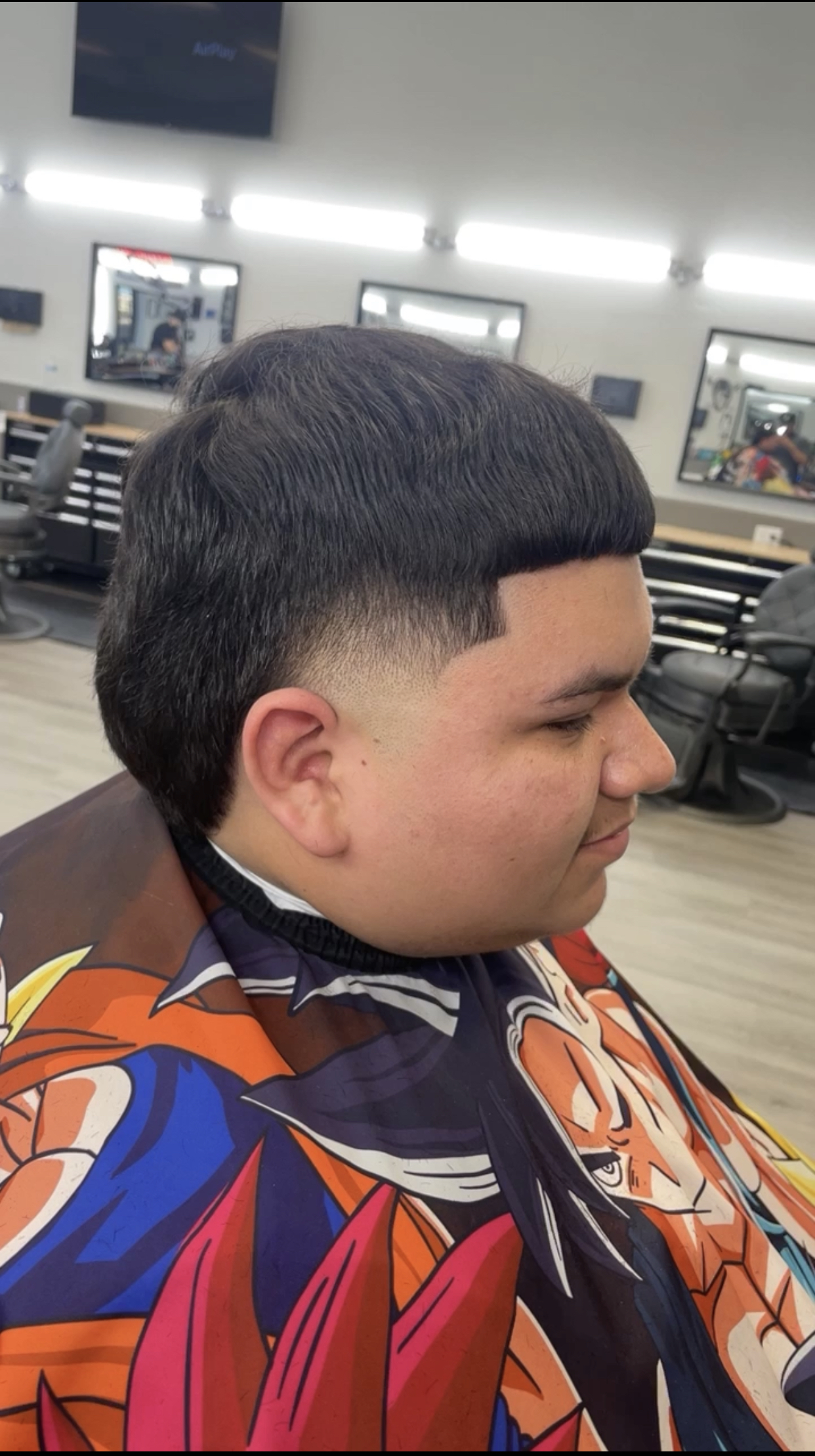 Profile view of a men's textured cut with taper fade and lineup